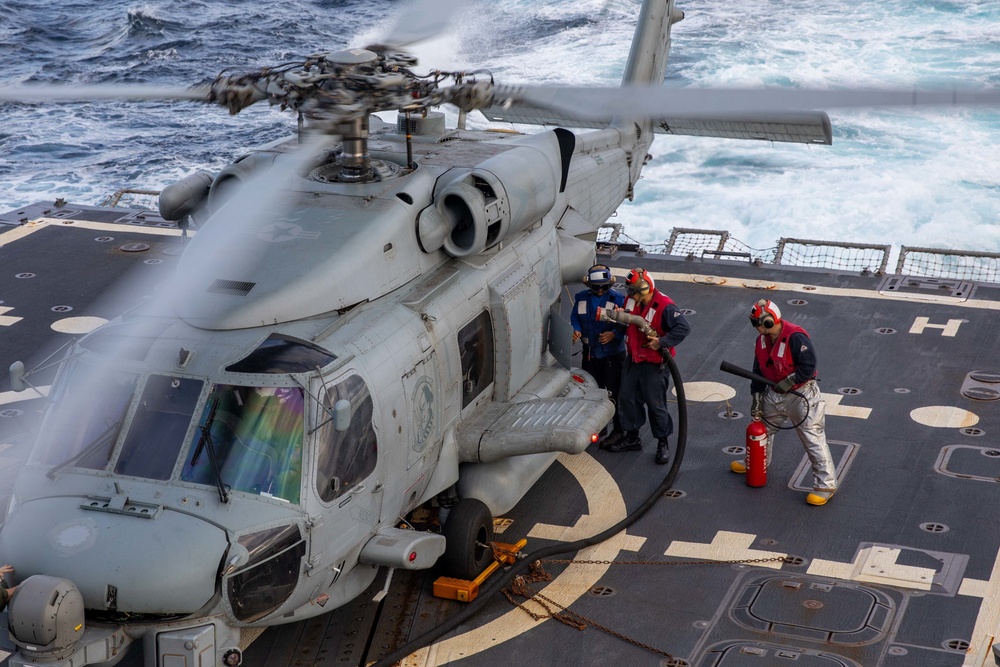Sailors aboard USS Dewey Refuel an MH-60R Helicopter assigned to HSM-51