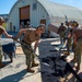 US Navy Seabees assigned to NMCB-5 place asphalt onboard Camp Shields