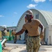 US Navy Seabees assigned to NMCB-5 place asphalt onboard Camp Shields