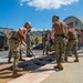 US Navy Seabees assigned to NMCB-5 place asphalt onboard Camp Shields