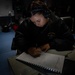 STGSN Triniti Vild Writes an Entry in the Sonar Control Log aboard USS Dewey