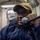 MMC Fatiou Assani Speaks into the Internal Voice Communication System aboard USS Dewey