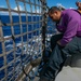 USS Sioux City Sailor Prepares to Lower Flight Deck Nets During Flight Ops