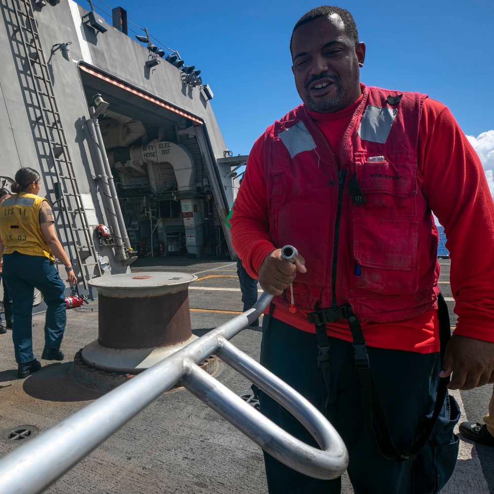 USS Sioux City Sailor Lowers Flight Deck Nets During Flight Ops