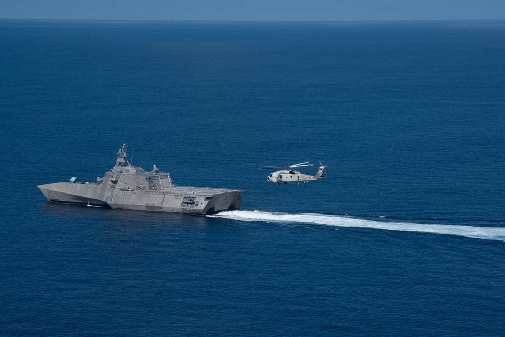 The Independence-variant littoral combat ship USS Jackson (LCS 6) and the Japanese Maritime Self Defense Force SH-60K Seahawk helicopter transit the South China Sea