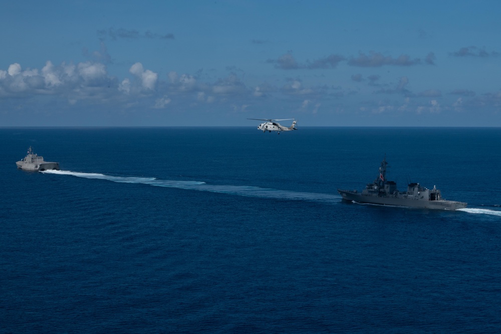 The Independence-variant littoral combat ship USS Jackson (LCS 6) and the Japanese Maritime Self Defense Force SH-60K Seahawk helicopter transit the South China Sea