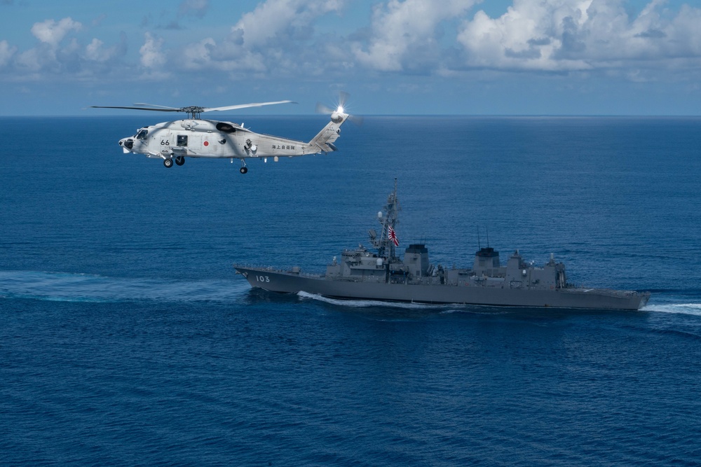 The Japanese Maritime Self Defense Force (MSDF) SH-60K Seahawk helicopter and Murasame-class Yuudachi (DDG 103) transit the South China Sea