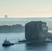 Tugs assist a dry-dock barge loaded with a section of the Golden Ray