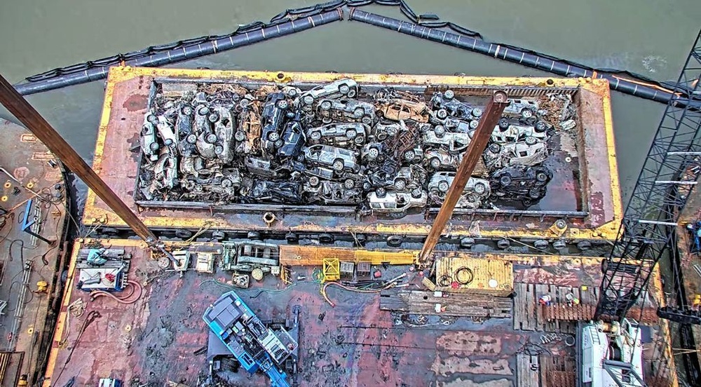 Several vehicles are stowed on a containment barge