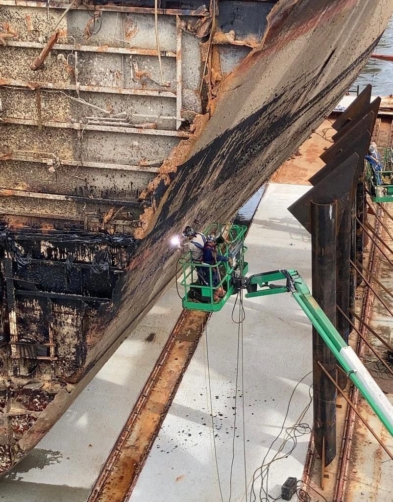 Welders attach cradles