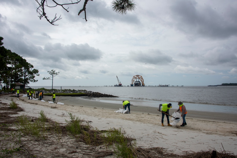 A shoreline clean-up team removes oiled sand