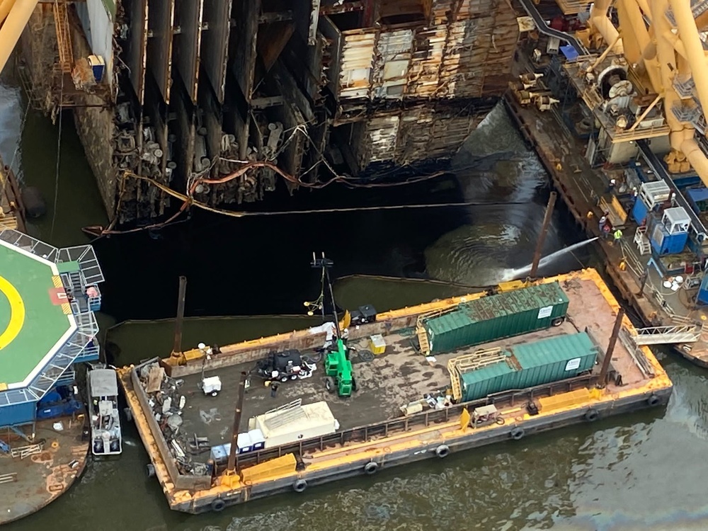 An oil recovery team pumps out oil