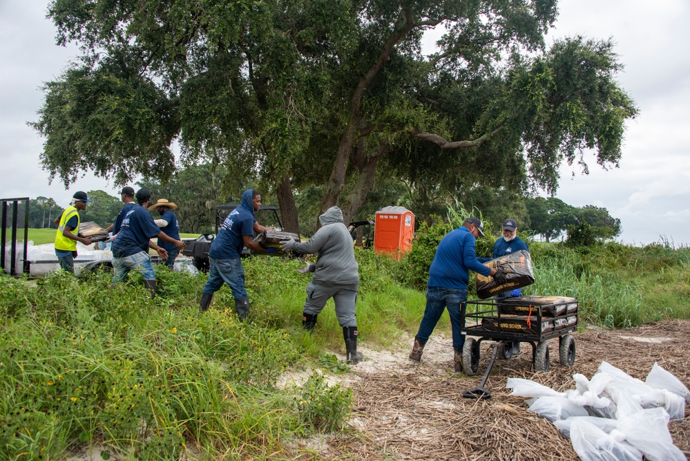 A shoreline clean-up team off loads multiple bags of sphagnum moss