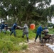 A shoreline clean-up team off loads multiple bags of sphagnum moss