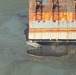 A skimmer vessel removes oil retained inside the boom