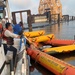 A response vessel crew removes oil from a Current Buster