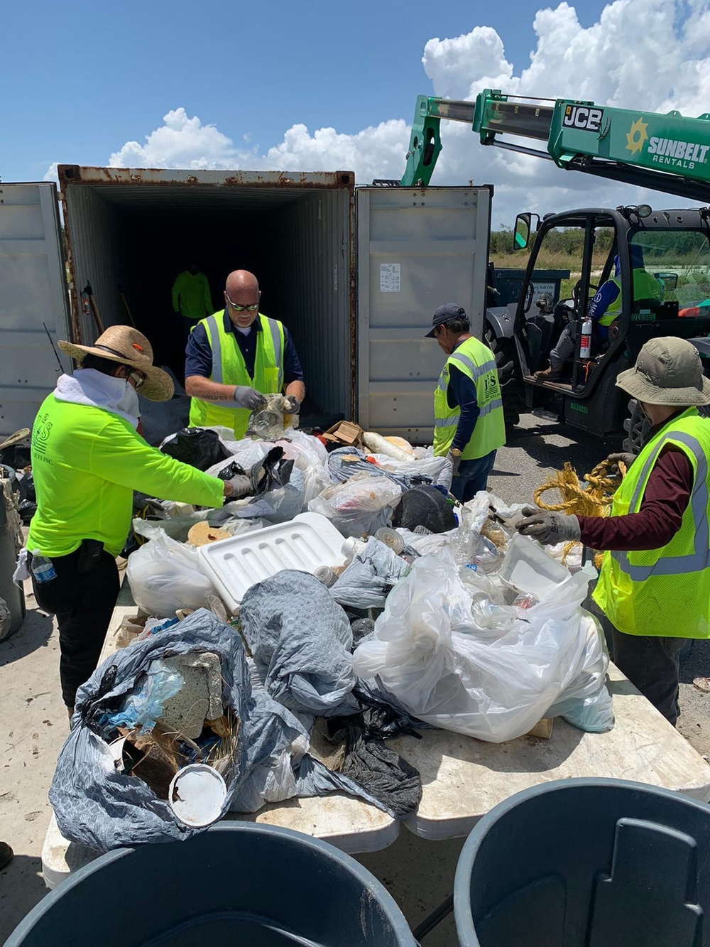 Decontamination facility workers sort through debris