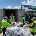 Decontamination facility workers sort through debris