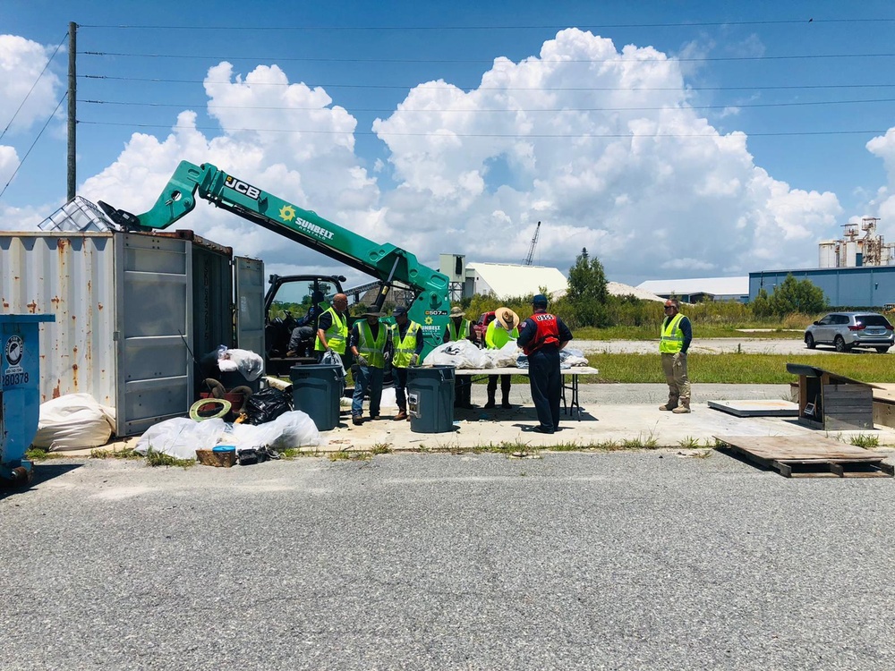 Personnel at the response decontamination facility sort debris