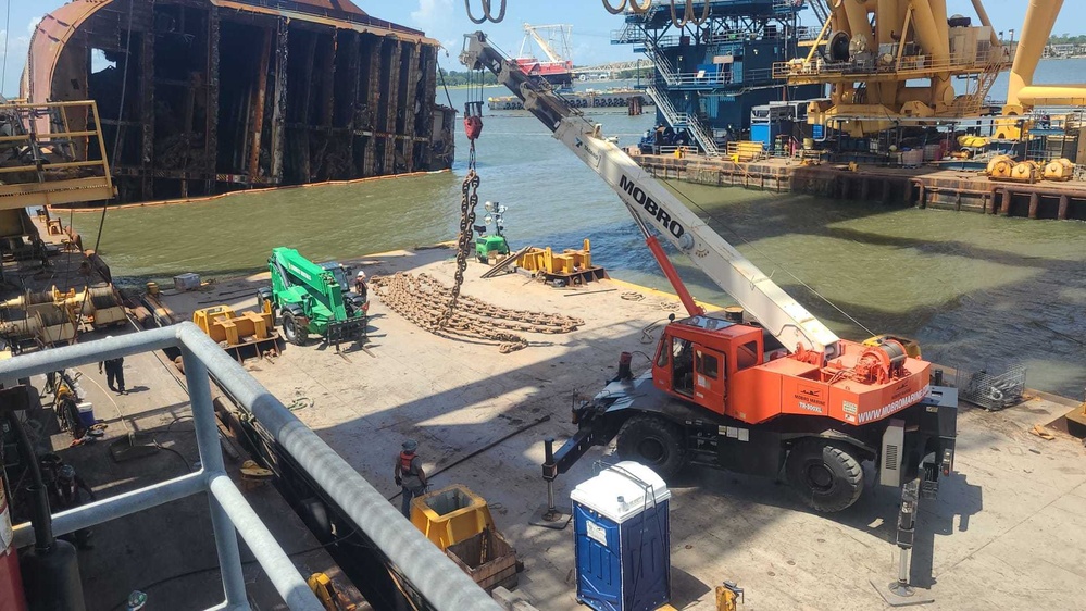 A crane operator hoists anchor chain