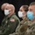 Kentucky Air Guard enters new era with arrival of C-130J Super Hercules aircraft Four military personnel are seated in a row, all wearing face masks, suggesting this was taken during the COVID-19 pandemic period. They are dressed in different military uniforms including OCP (Operational Camouflage Pattern) and flight suits, indicating a mixed-branch or multi-role gathering. The individuals appear to be attentively observing something off-camera, likely a briefing or ceremony.
