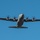 Kentucky Air Guard enters new era with arrival of C-130J Super Hercules aircraft A United States Air Force (USAF) military transport aircraft, identifiable as a C-130 Hercules or variant, is photographed from below against a clear blue sky. The aircraft is in level flight with all four turboprop engines running, as evidenced by the motion-blurred propellers. The 'USAF' marking is clearly visible on the right wing.