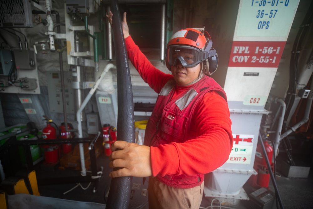 USS Sioux City Sailor Rolls Out the Hose During Flight Deck Fire Drill