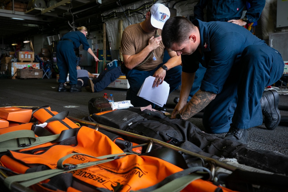 USS Sioux City Sailor Prepares to Move a Dummy Onto a Rescue Litter During Flight Deck Fire Drill