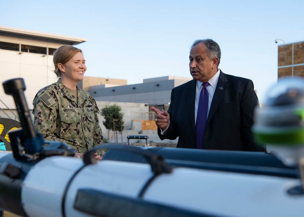 Secretary of the Navy Carlos Del Toro discusses unmanned underwater vehicles with Lt. Olivia Morrell during his visit to Naval Special Warfare (NSW) units in the San Diego area.