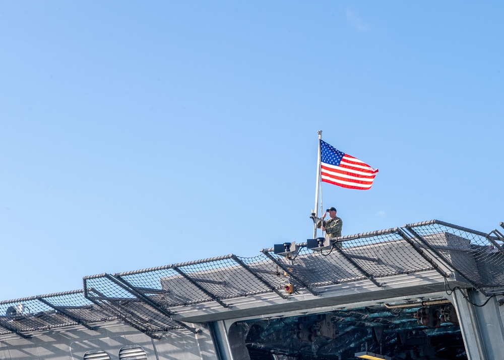 USS Charleston Sailor Observes Morning Colors