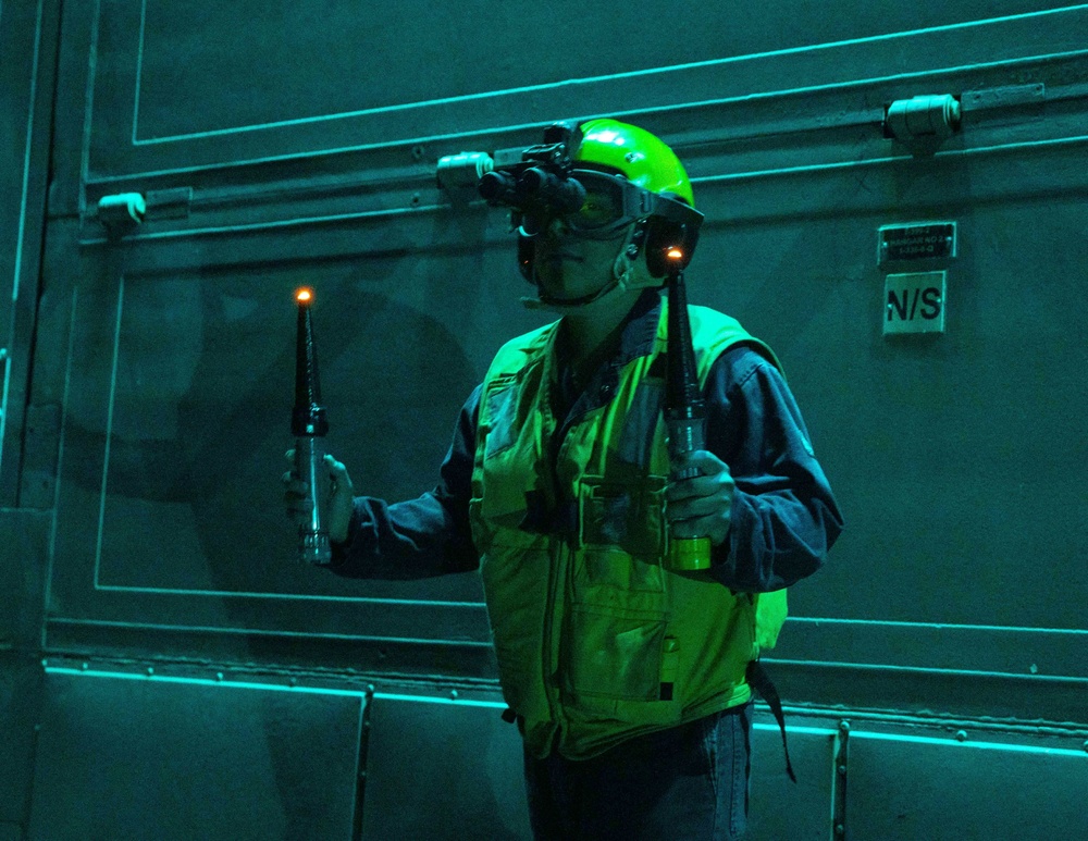 SN John Lopez Signals an MH-60R Helicopter aboard the USS Dewey