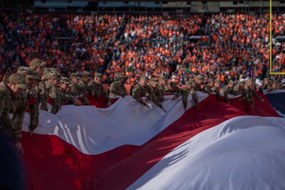Fort Carson Soldiers hold flag at Broncos game