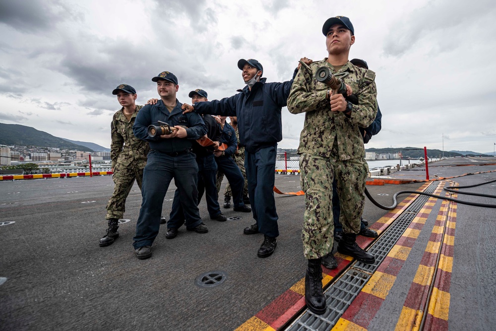 Sailors assigned to the forward-deployed amphibious assault ship USS America (LHA 6) prepare to participate in a firefighting drill on the ship’s flight deck.