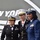 New York Jets Salute to Service Game 11/14/21 Three female military officers in dress uniforms pose together in front of a New York Jets backdrop, suggesting a military appreciation event at a Jets game or venue. Each officer represents a different branch of the U.S. armed forces, identifiable by their distinct uniforms and insignia. All three are smiling and appear to be at an official public appearance.