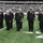 New York Jets Salute to Service Game 11/14/21 A group of U.S. Navy personnel in dress uniforms are standing at attention on the field of MetLife Stadium during an NFL New York Jets game. The formation includes enlisted sailors in Service Dress Blue 'Crackerjack' uniforms and officers/senior enlisted in Service Dress Blue coat uniforms. This appears to be a military appreciation or ceremonial event held during a Jets home game.