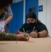 Airmen and Mañe'lu children decorate boxes for OCD