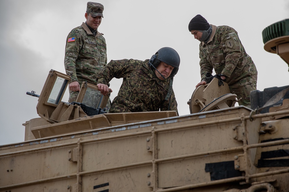 Latvian Land Forces Mechanized Brigade Commander Col. Sandris Gaugers fires an M1 Abrams with 3rd Battalion, 66th Armored Regiment (3-66), 1st Armored Brigade Combat Team, 1st Infantry Division