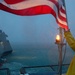 USS Charleston Sailor Observes Evening Colors