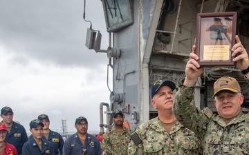 Capt. Joe Ring presents a USS Arizona relic to USS Port Royal