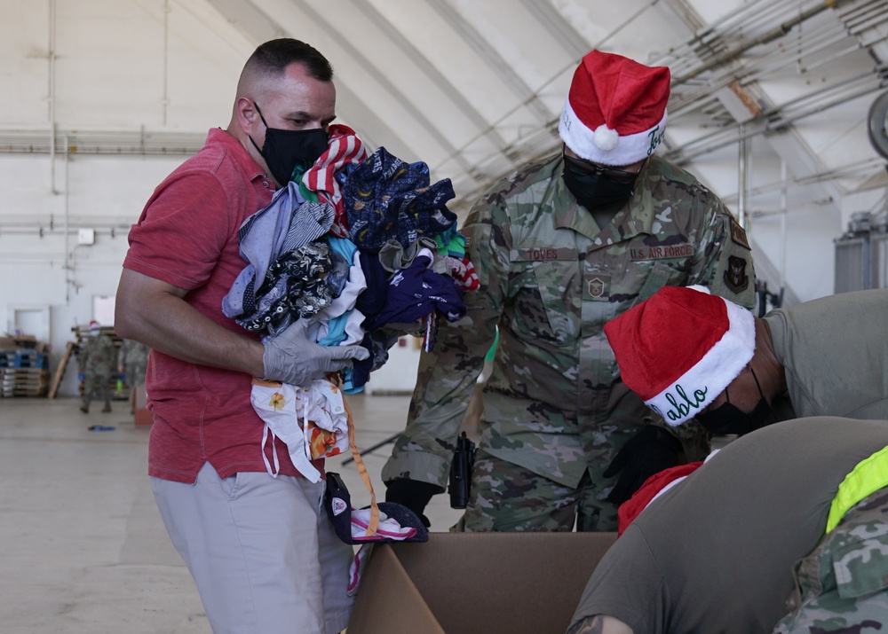 Volunteers pack donated goods into airdrop bundles during the 70th annual Operation Christmas Drop