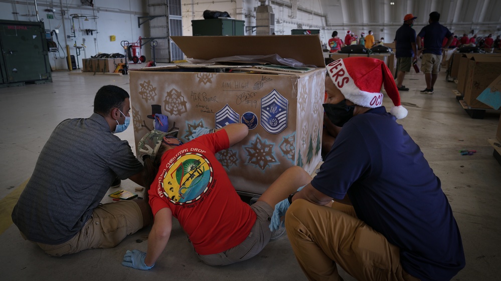 Volunteers pack donated goods into airdrop bundles during the 70th annual Operation Christmas Drop