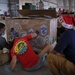 Volunteers pack donated goods into airdrop bundles during the 70th annual Operation Christmas Drop