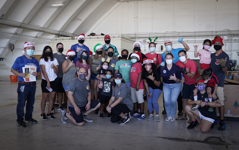 Volunteers pack donated goods into airdrop bundles during the 70th annual Operation Christmas Drop