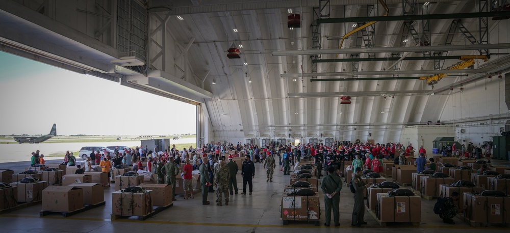 Volunteers pack donated goods into airdrop bundles during the 70th annual Operation Christmas Drop