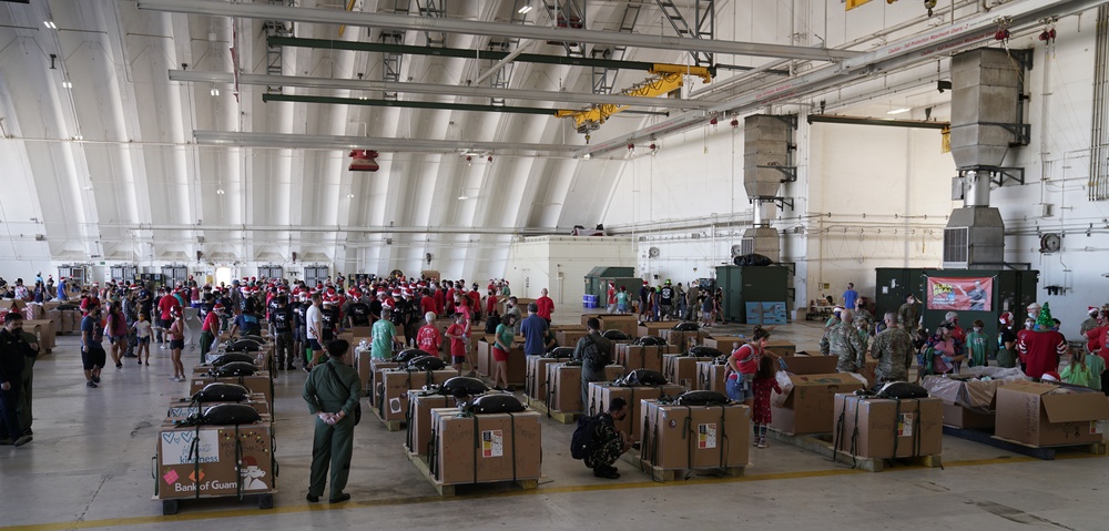 Volunteers pack donated goods into airdrop bundles during the 70th annual Operation Christmas Drop