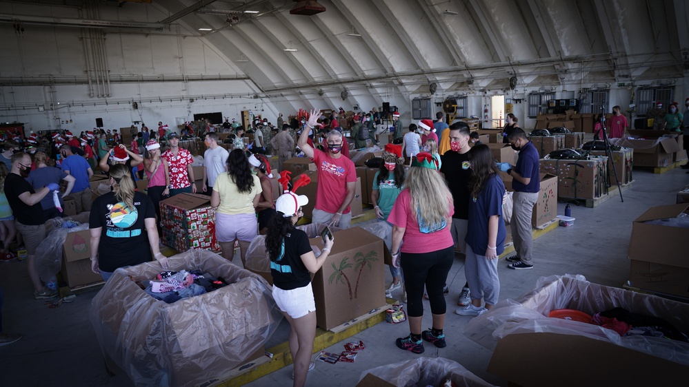 Volunteers pack donated goods into airdrop bundles during the 70th annual Operation Christmas Drop