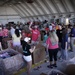 Volunteers pack donated goods into airdrop bundles during the 70th annual Operation Christmas Drop