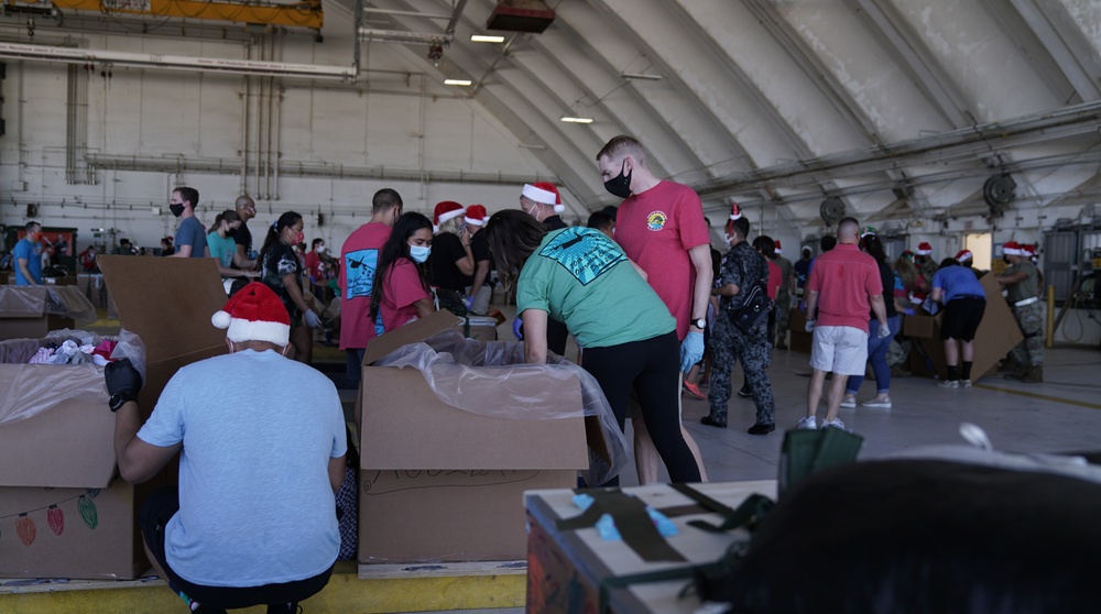 Volunteers pack donated goods into airdrop bundles during the 70th annual Operation Christmas Drop