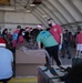 Volunteers pack donated goods into airdrop bundles during the 70th annual Operation Christmas Drop