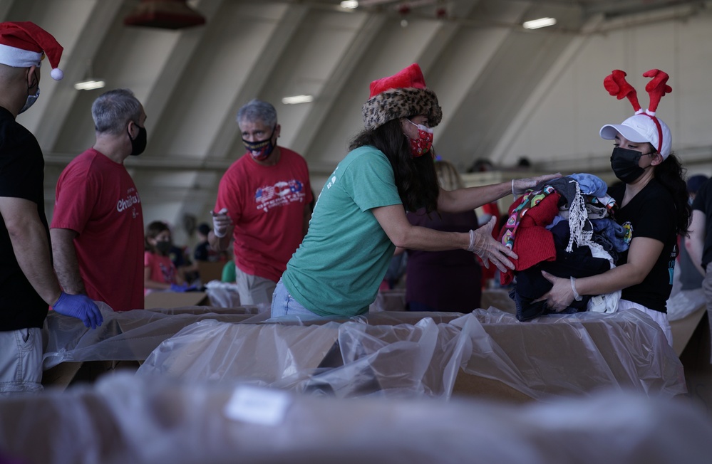 Volunteers pack donated goods into airdrop bundles during the 70th annual Operation Christmas Drop